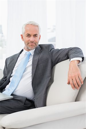 sophisticated home smile - Portrait of a relaxed mature businessman with laptop sitting on sofa in living room at home Stock Photo - Budget Royalty-Free & Subscription, Code: 400-07230768