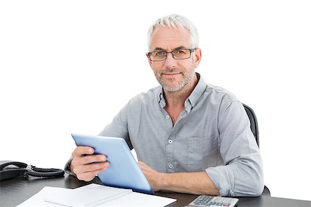 simsearch:400-07230809,k - Portrait of a mature businessman with digital tablet and telephone at desk against white background Foto de stock - Super Valor sin royalties y Suscripción, Código: 400-07230805