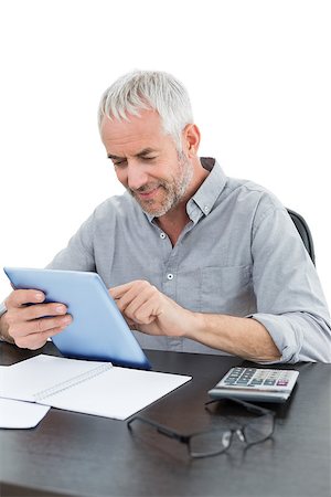 simsearch:400-07230809,k - Mature businessman with digital tablet and calculator at desk against white background Foto de stock - Super Valor sin royalties y Suscripción, Código: 400-07230808