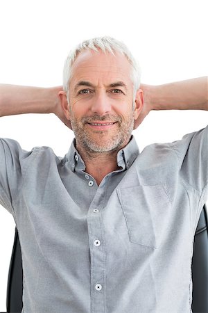Portrait of a relaxed mature businessman with hands behind head over white background Photographie de stock - Aubaine LD & Abonnement, Code: 400-07230800