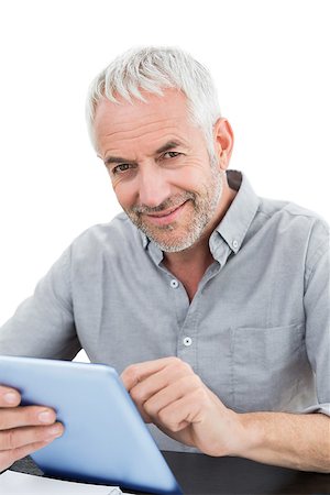 simsearch:400-07230809,k - Portrait of a smiling mature businessman using digital tablet against white background Foto de stock - Super Valor sin royalties y Suscripción, Código: 400-07230810