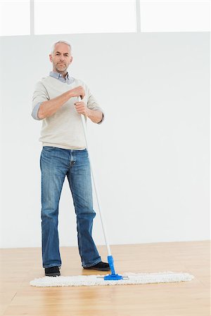 simsearch:400-07228658,k - Full length portrait of a mature man standing with a mop in a bright room Stockbilder - Microstock & Abonnement, Bildnummer: 400-07230859