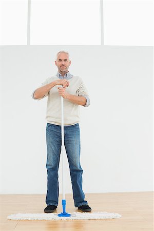 simsearch:400-07228658,k - Full length portrait of a mature man standing with a mop in a bright room Stockbilder - Microstock & Abonnement, Bildnummer: 400-07230860