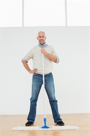 simsearch:400-07228658,k - Full length portrait of a mature man standing with a mop in a bright room Stockbilder - Microstock & Abonnement, Bildnummer: 400-07230861