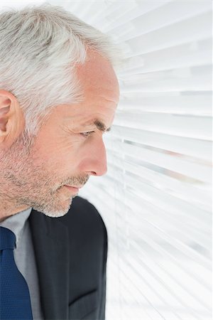 simsearch:400-07266908,k - Close-up of a serious mature businessman peeking through blinds in the office Photographie de stock - Aubaine LD & Abonnement, Code: 400-07230920