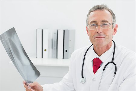 simsearch:400-07269250,k - Portrait of a confident male doctor with x-ray picture of lungs in the medical office Stock Photo - Budget Royalty-Free & Subscription, Code: 400-07230987