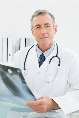 simsearch:400-07269250,k - Portrait of a confident male doctor with x-ray picture of lungs in the medical office Stock Photo - Budget Royalty-Free & Subscription, Code: 400-07230992