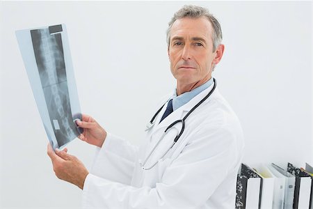 simsearch:400-07274751,k - Portrait of a serious male doctor with x-ray picture of spine in the medical office Foto de stock - Super Valor sin royalties y Suscripción, Código: 400-07231021