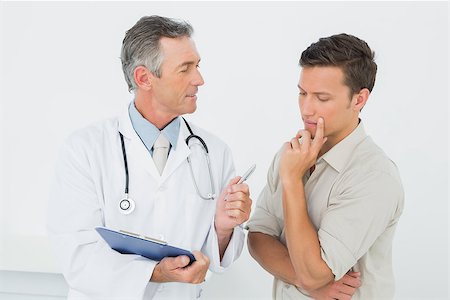 simsearch:400-07269643,k - Male doctor in conversation with patient in the medical office Fotografie stock - Microstock e Abbonamento, Codice: 400-07231071