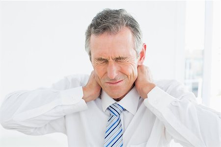 Close-up of a mature man suffering from neck pain over white background Stock Photo - Budget Royalty-Free & Subscription, Code: 400-07231174