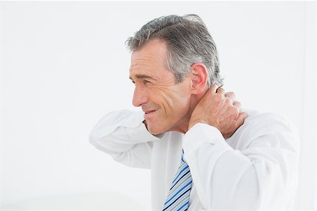 Side view of a mature man suffering from neck pain over white background Stock Photo - Budget Royalty-Free & Subscription, Code: 400-07231175