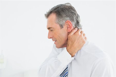 Close-up side view of a mature man suffering from neck pain over white background Stock Photo - Budget Royalty-Free & Subscription, Code: 400-07231170