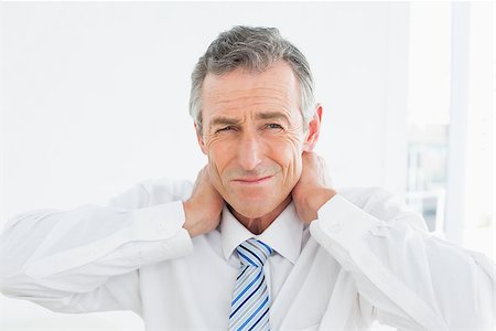 Portrait of a mature man suffering from neck pain over white background Stock Photo - Budget Royalty-Free & Subscription, Code: 400-07231173