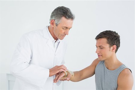 simsearch:400-07269643,k - Male doctor examining a patients hand in the medical office Fotografie stock - Microstock e Abbonamento, Codice: 400-07231198