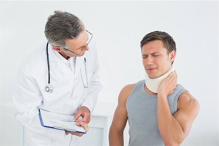 simsearch:400-07269643,k - Male doctor listening to patient with concentration at medical office Fotografie stock - Microstock e Abbonamento, Codice: 400-07231193