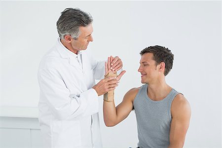 simsearch:400-07269643,k - Male doctor examining a patients hand in the medical office Fotografie stock - Microstock e Abbonamento, Codice: 400-07231202