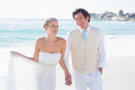 simsearch:400-07664797,k - Newlyweds walking hand in hand and laughing at the beach Stock Photo - Budget Royalty-Free & Subscription, Code: 400-07231283