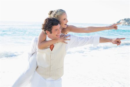 simsearch:400-07664797,k - Newlyweds pointing to something and smiling at the beach Stock Photo - Budget Royalty-Free & Subscription, Code: 400-07231305