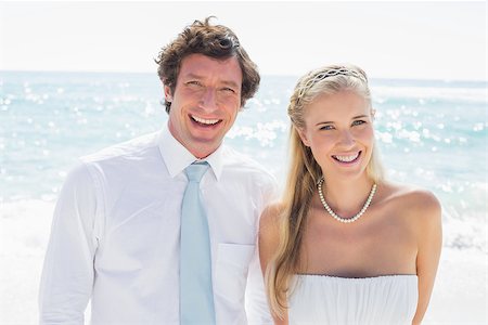 simsearch:400-07664797,k - Romantic couple smiling at camera on their wedding day at the beach Stock Photo - Budget Royalty-Free & Subscription, Code: 400-07231504