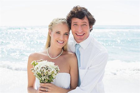 simsearch:400-07664797,k - Romantic couple on their wedding day smiling at camera at the beach Stock Photo - Budget Royalty-Free & Subscription, Code: 400-07231515