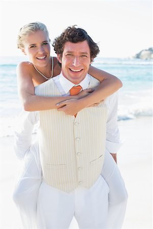 simsearch:400-07664797,k - Happy bride getting a piggy back from husband at the beach Stock Photo - Budget Royalty-Free & Subscription, Code: 400-07231536