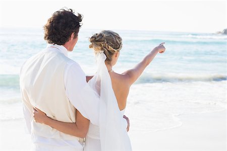 simsearch:400-07664797,k - Newlyweds standing by the sea with wife pointing at the beach Stock Photo - Budget Royalty-Free & Subscription, Code: 400-07231545