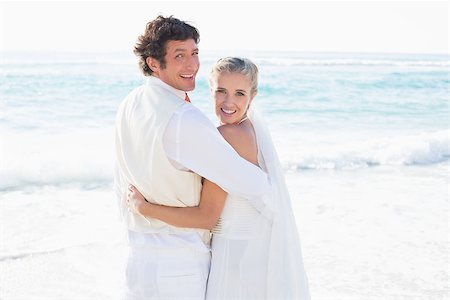 simsearch:400-07664797,k - Newlyweds standing by the sea smiling at camera at the beach Stock Photo - Budget Royalty-Free & Subscription, Code: 400-07231542