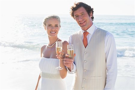 simsearch:400-07664797,k - Young newlyweds toasting with champagne smiling at camera at the beach Stock Photo - Budget Royalty-Free & Subscription, Code: 400-07231553