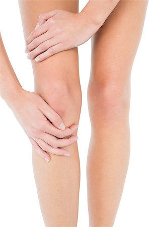 Close-up mid section of a young woman with knee pain over white background Stock Photo - Budget Royalty-Free & Subscription, Code: 400-07231678