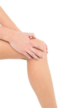 Close-up mid section of a young woman with knee pain over white background Stock Photo - Budget Royalty-Free & Subscription, Code: 400-07231681