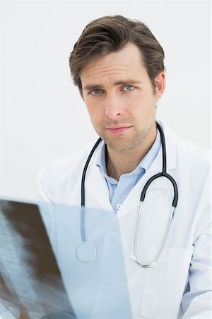 simsearch:400-04552598,k - Portrait of a male doctor examining spine x-ray over white background Foto de stock - Super Valor sin royalties y Suscripción, Código: 400-07231966