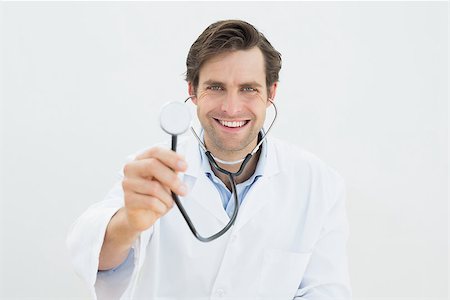 simsearch:400-04217553,k - Portrait of a smiling male doctor with stethoscope over white background Foto de stock - Royalty-Free Super Valor e Assinatura, Número: 400-07231968