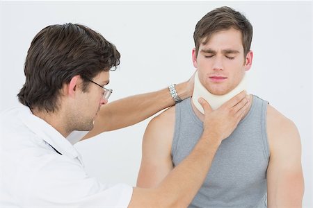 simsearch:400-07269643,k - Male doctor examining a patients neck over white background Fotografie stock - Microstock e Abbonamento, Codice: 400-07232117