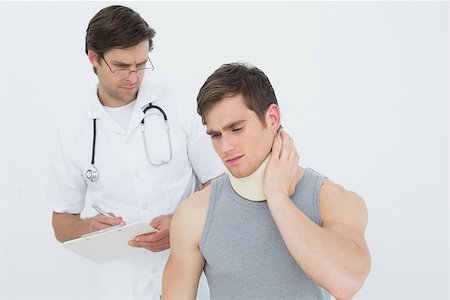 simsearch:400-07269643,k - Male doctor examining a patients neck over white background Fotografie stock - Microstock e Abbonamento, Codice: 400-07232112