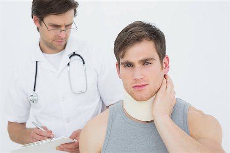 simsearch:400-07269643,k - Male doctor examining a patients neck over white background Fotografie stock - Microstock e Abbonamento, Codice: 400-07232113