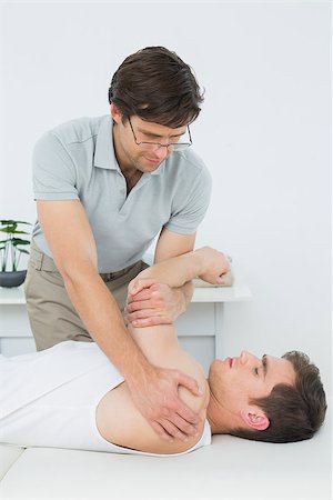 simsearch:400-04337005,k - Male physiotherapist examining a young mans hand in the medical office Foto de stock - Super Valor sin royalties y Suscripción, Código: 400-07232142