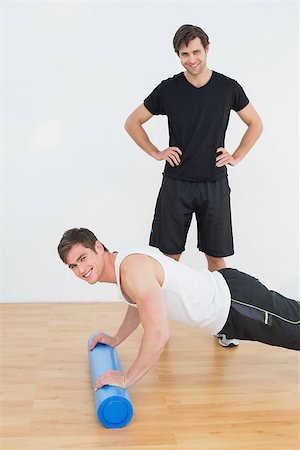simsearch:400-07232187,k - Portrait of physical therapist with young man doing push ups in the gym at hospital Foto de stock - Royalty-Free Super Valor e Assinatura, Número: 400-07232196