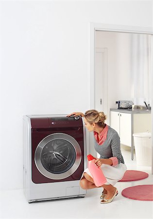 smiling woman dooing  laundry with washing machine Foto de stock - Super Valor sin royalties y Suscripción, Código: 400-07244397