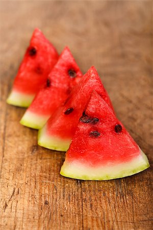 simsearch:400-07249854,k - Four watermelon slices on rustic wooden table Stockbilder - Microstock & Abonnement, Bildnummer: 400-07244517