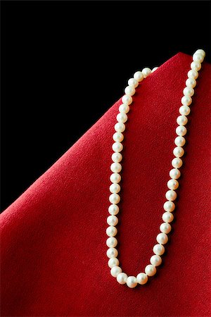 simsearch:400-07758089,k - Pearl necklace on red cloth black background Photographie de stock - Aubaine LD & Abonnement, Code: 400-07245453