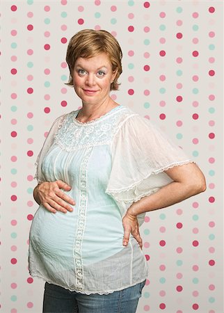 simsearch:400-07252384,k - Cheerful pregnant woman on polka dot background Photographie de stock - Aubaine LD & Abonnement, Code: 400-07245517
