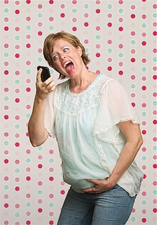 phone with pain - Pregnant woman holding belly while yelling at phone Stock Photo - Budget Royalty-Free & Subscription, Code: 400-07245513