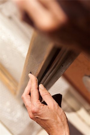 Hands of a woman with sandpaper doing DIY work on wooden fixtures Fotografie stock - Microstock e Abbonamento, Codice: 400-07246574