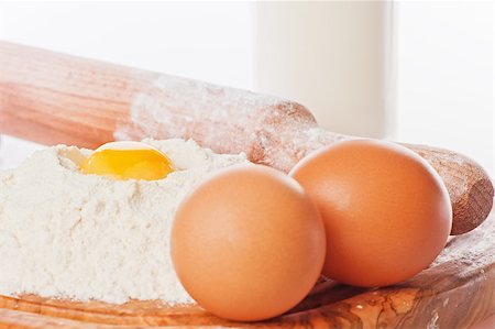 simsearch:632-05991303,k - Vintage rolling pin with flour and eggs. Country still life images with soft lighting and small degrees of freedom (selective focus on the yolk) Photographie de stock - Aubaine LD & Abonnement, Code: 400-07247139
