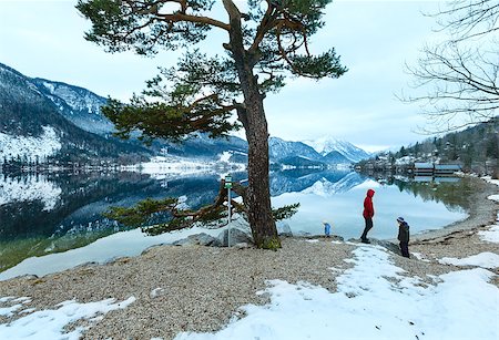 simsearch:400-06748366,k - Cloudy winter Alpine  lake Grundlsee view (Austria) with fantastic pattern-reflection on water and family on shore. Stock Photo - Budget Royalty-Free & Subscription, Code: 400-07248205