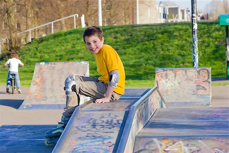 smiling teenage boy in roller-blading protection kit in a skate park Stockbilder - Microstock & Abonnement, Bildnummer: 400-07248348