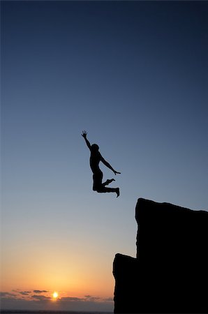 simsearch:400-08035788,k - people jumping from the top of the mountain on the background of the sunset Fotografie stock - Microstock e Abbonamento, Codice: 400-07248741