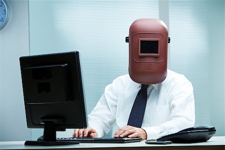 robotic - An office worker at his desk wearing a welder's mask Stock Photo - Budget Royalty-Free & Subscription, Code: 400-07249831