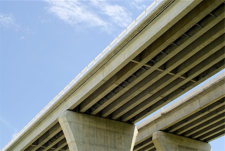 Underneath pair of large concrete highway bridges against partly cloudy blue sky. Fotografie stock - Microstock e Abbonamento, Codice: 400-07254142