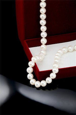 simsearch:400-07758089,k - Pearl necklace lies on a red box on a black background. Photographie de stock - Aubaine LD & Abonnement, Code: 400-07254390